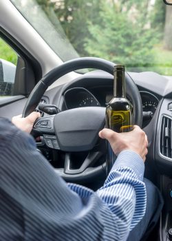 driver-holding-steering-wheel-bottle-alcohol-beverage.jpg